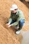 Young farmer checking quality of brewers spent grains in open storage