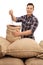 Young farmer filling a burlap sack with coffee beans