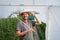 Young farmer in front of small greenhouse. Small business entrepreneur.