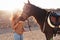 Young farmer having fun with horses inside stable - Happy girl playing with animals in corral ranch