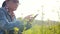 Young farmer observing in a tablet computer in a fallow field.