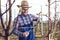 Young farmer pruning fruit tree. Agricultural occupation. Gardening at spring