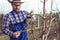 Young farmer pruning fruit tree. Agricultural occupation. Gardening at spring