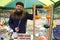 a young farmer sells his produce at a fair in the park