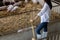 Young farmer with shovel working in in organic farm pig. Agriculture and livestock industry