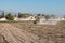 Young farmer tilling the land with a tractor on his small plot of land