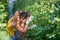 Young farmer woman holding leaf of the tomato plant vegetable looking for insects and vegetable checking for diseases on the leaf