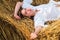 Young farmer woman while laying in hayloft. Sensual girl lying in the hay, haystack. Female portrait in field in