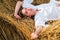 Young farmer woman while laying in hayloft. Sensual girl lying in the hay, haystack. Female portrait in field in