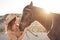 Young farmer woman playing with her bitless horse in a sunny day inside corral ranch - Concept about love between people and