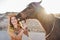 Young farmer woman playing with her horse in a sunny day inside corral ranch - Concept about love between people and animals -