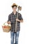 Young farmer with work tools and basket with vegetables and fruit