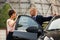 Young fashion business man and woman talking by car