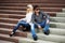 Young fashion couple in conflict sitting on the steps