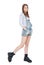 Young fashion girl in jeans overalls posing isolated