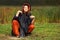 Young fashion hipster woman in rasta poncho sitting on the ground
