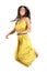 Young fashion model in yellow dress jumps in mid air.