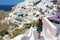 Young fashion woman with green dress and walking on stairs in Oia, Santorini. Female travel tourist on her summer vacations