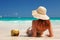 Young fashion woman relax on the beach. Happy island lifestyle. White sand, blue cloudy sky and crystal sea of tropical beach.