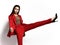 Young fashionable beautiful business woman wear expensive designer stylish red office suit  doing a great stretch kick