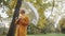 Young fashionable blond caucasian woman with transparent umbrela looking around in the park in autumn