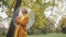 Young fashionable caucasian woman with transparent umbrela looking around in the park in autumn