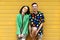 Young fashionable couple on yellow background