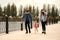 A young, fashionable family walks along the embankment of the river, mom and dad hold daughter`s hands