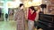 A young fashionable girl in a hat chooses an autumn coat in a clothing store.