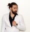 Young, fashionable male model with long hair and beard posing in studio on isolated background. Fashion, business, modeling