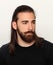 Young, fashionable male model with long hair and beard posing in studio on isolated background. Fashion, business, modeling