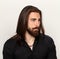 Young, fashionable male model with long hair and beard posing in studio on isolated background. Fashion, business, modeling