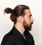 Young, fashionable male model with long hair and beard posing in studio on isolated background. Fashion, business, modeling