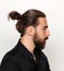 Young, fashionable male model with long hair and beard posing in studio on isolated background. Fashion, business, modeling