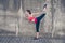 Young fashionable sportswoman is stretching on the street on a s