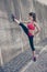 Young fashionable sportswoman is stretching on the street on a s