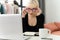 Young fashionable woman working remotely at home using a laptop. The girl conducts a video conference online