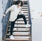 Young fashionably dressed man in a cool outfit posing on a metal staircase. Afro style hair. Streetstyle. Youth fashion.