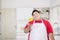 Young fat man throwing a paprika on his hand