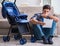 Young father assembling baby pram at home