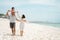 Young father carrying daughter on the shoulder when enjoy the beach with mother