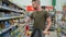 Young father is choosing baby food in supermarket, male shopper