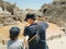 Young father dad and his school boy kid son tourists visiting ancient antique coliseum amphitheater ruins in hot summer