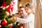 Young father with daugter decorating Christmas tree together.