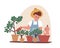 Young father doing gardening with baby, sitting in pot. Dad watering plants. Household chores and fatherhood concept