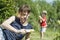 Young father or elder brother and a little boy - a son - play water guns outdoors in the summer among green grass. A blurry