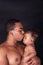 Young father and his baby kissing his child both african american in an intimate and happy moment