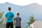 Young father with his child son standing together near a hiker tent in summer mountains. Active family recreation concept