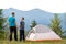 Young father with his child son standing together near a hiker tent in summer mountains. Active family recreation concept