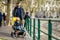 Young father with his toddler son in a stroller having fun in marina of Lecco town. Picturesque waterfront of Lecco located on the